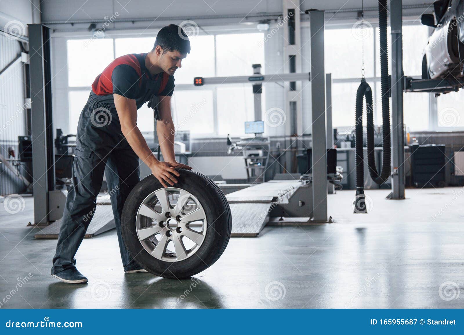 Such A Clean Floor Mechanic Holding A Tire At The Repair Garage