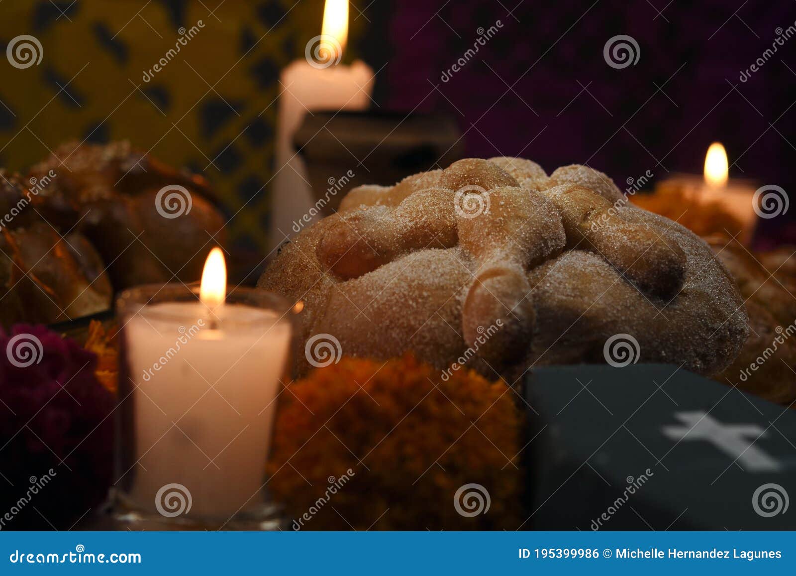 sugary bread of the dead celebrating dia de muertos and using cempasuchienlt flowers on an altar