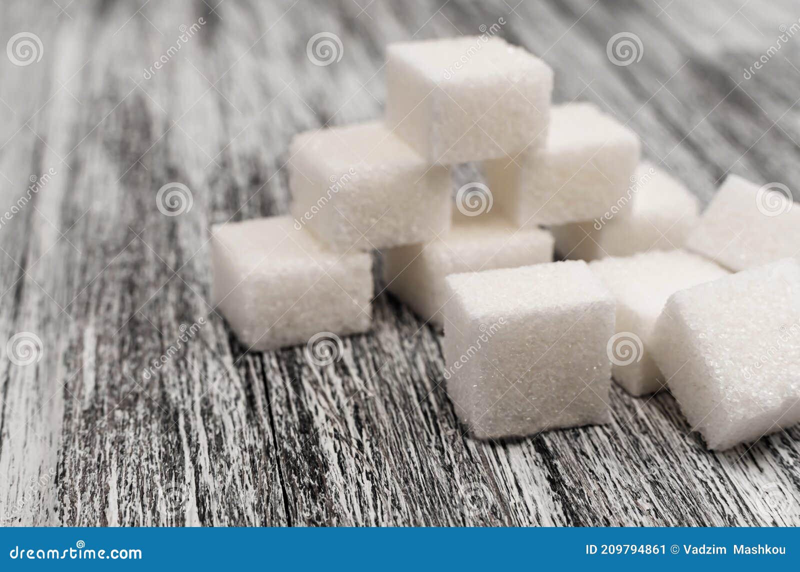 sugar cubes lie on a wooden background of gray color. sugar