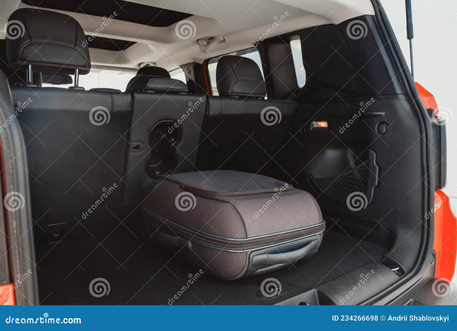 Suitcase in the Trunk of a Car Parked in the Parking Lot Stock Photo