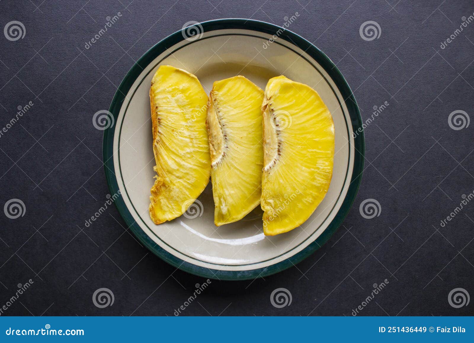 sukun goreng or fried breadfruit served at plate on black background.