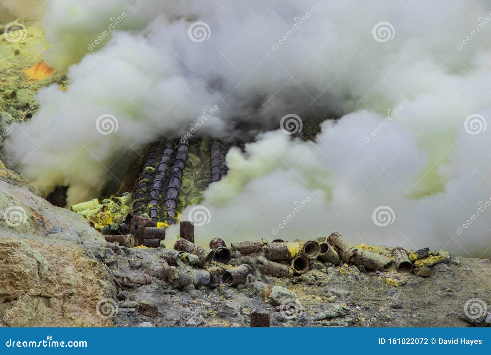 sulfur mining operation in mount ijen, indonesia. toxic gas escaping from volcanic vents. pipes to divert the gas for condensing t