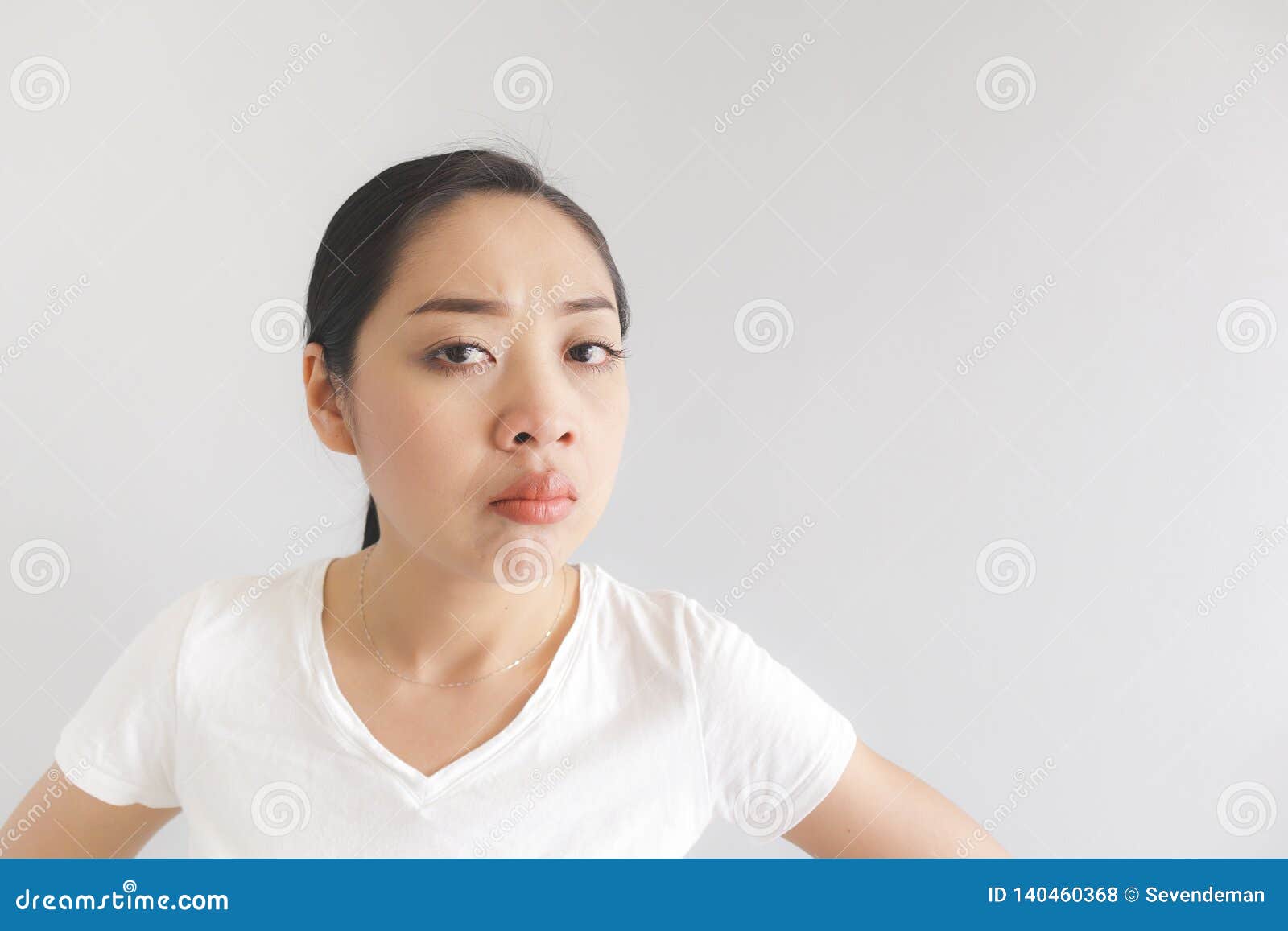 sulk and grumpy face expression of woman in white t-shirt. concept of offended peevish and sulky