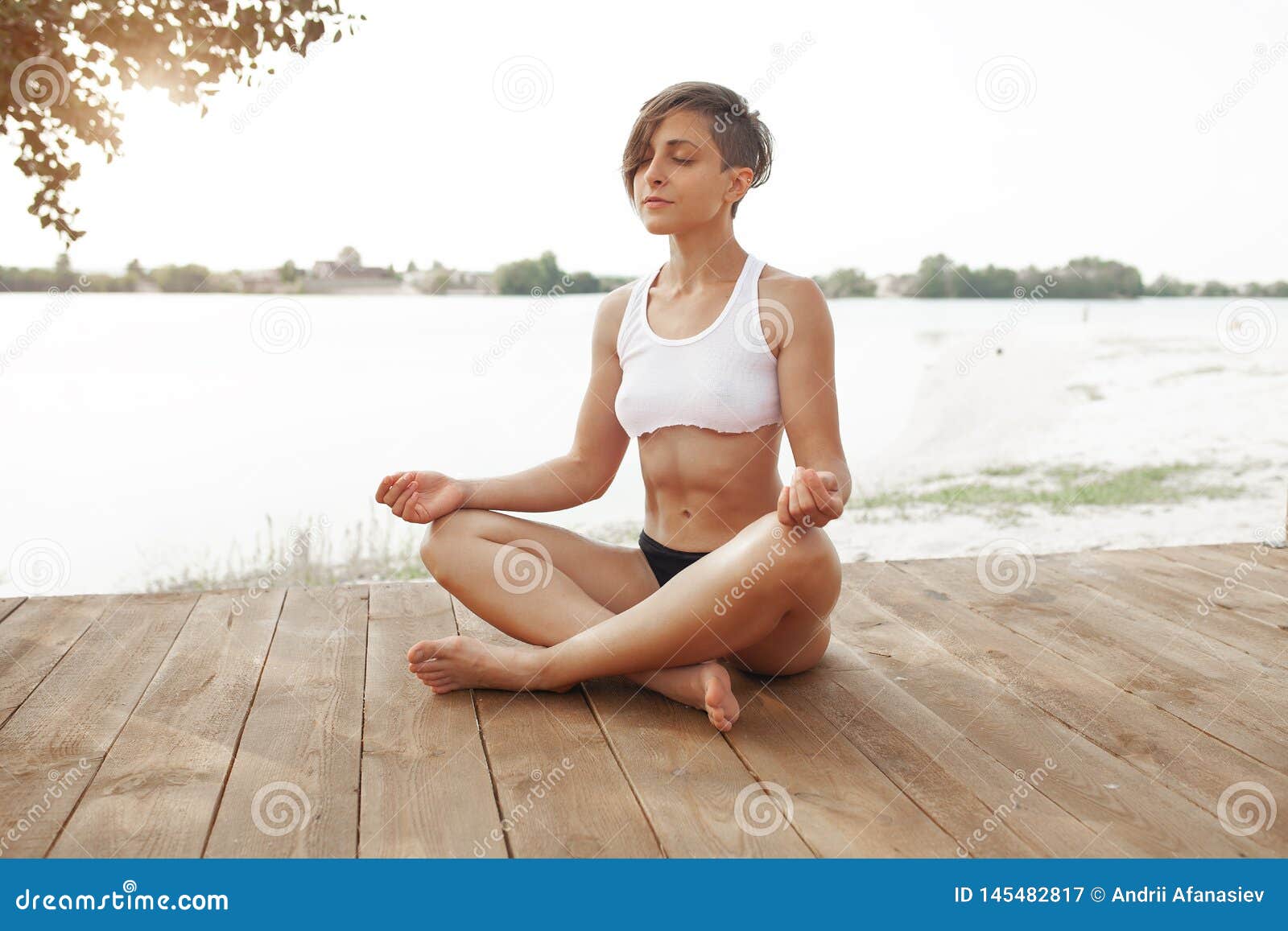 Summer. a Beautiful Girl with a Short Haircut Practices Yoga in the Lotus  Position Stock Image - Image of lifestyle, nature: 145482817