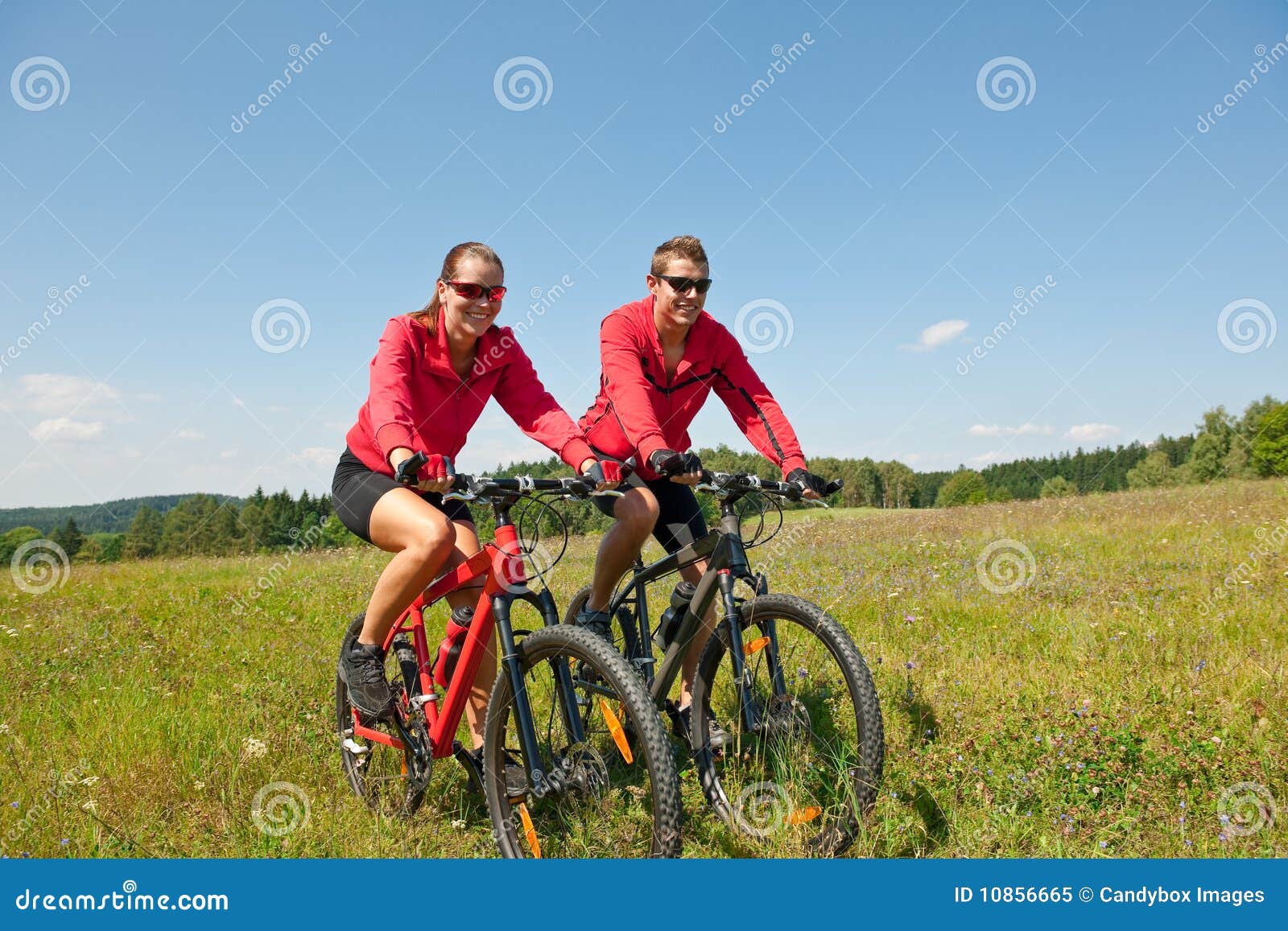 summer bike - young sportive couple in meadow