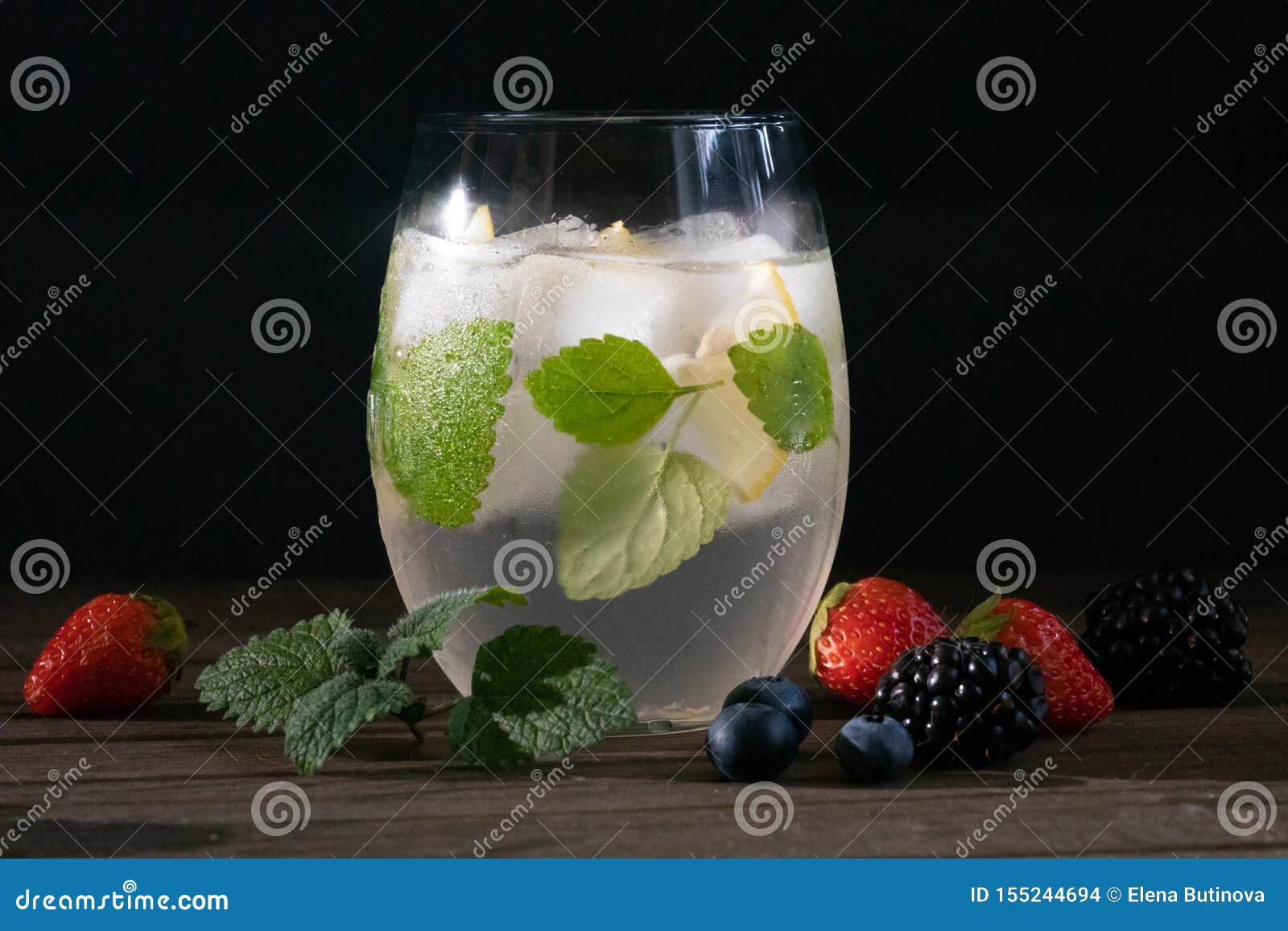 summer  cocktail bmojito with rum, green mint, lime and crushed ice and  berries
