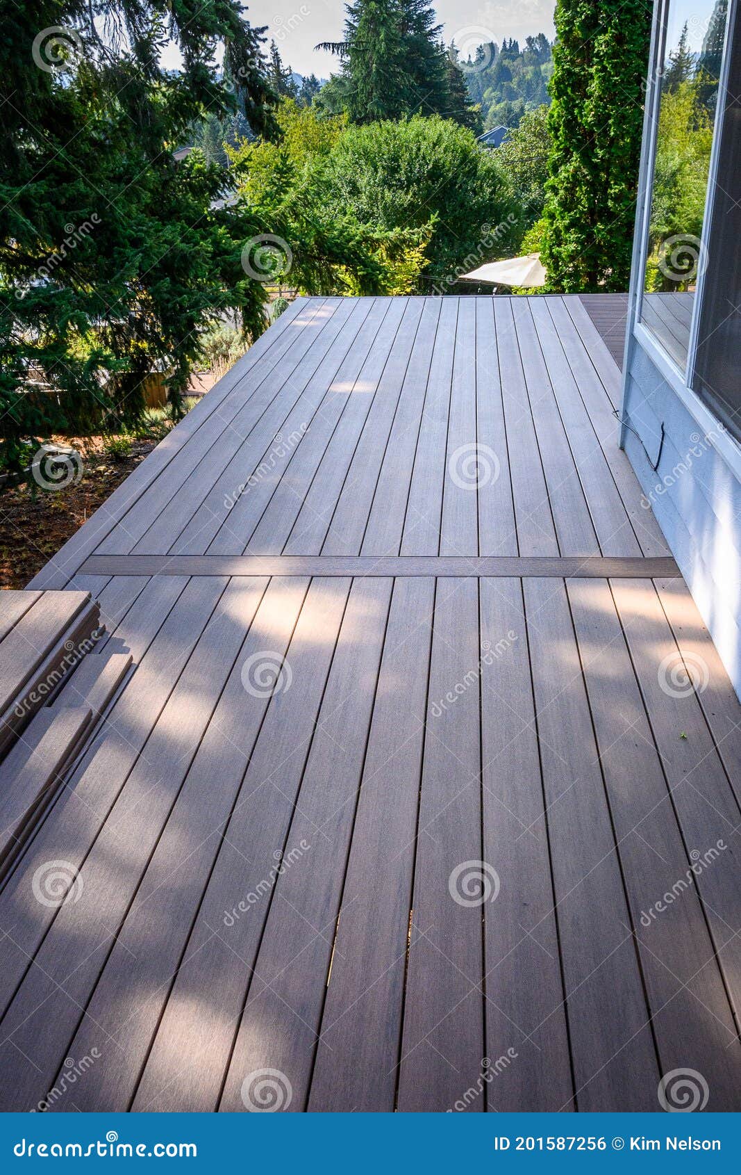 summer construction, outdoor deck under construction, new manufactured wood planks installed