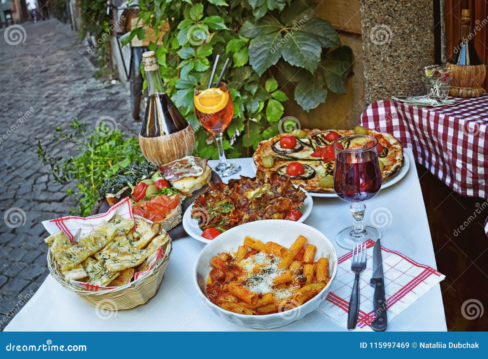 unidentified people eating traditional italian food in outdoor restaurant in trastevere district