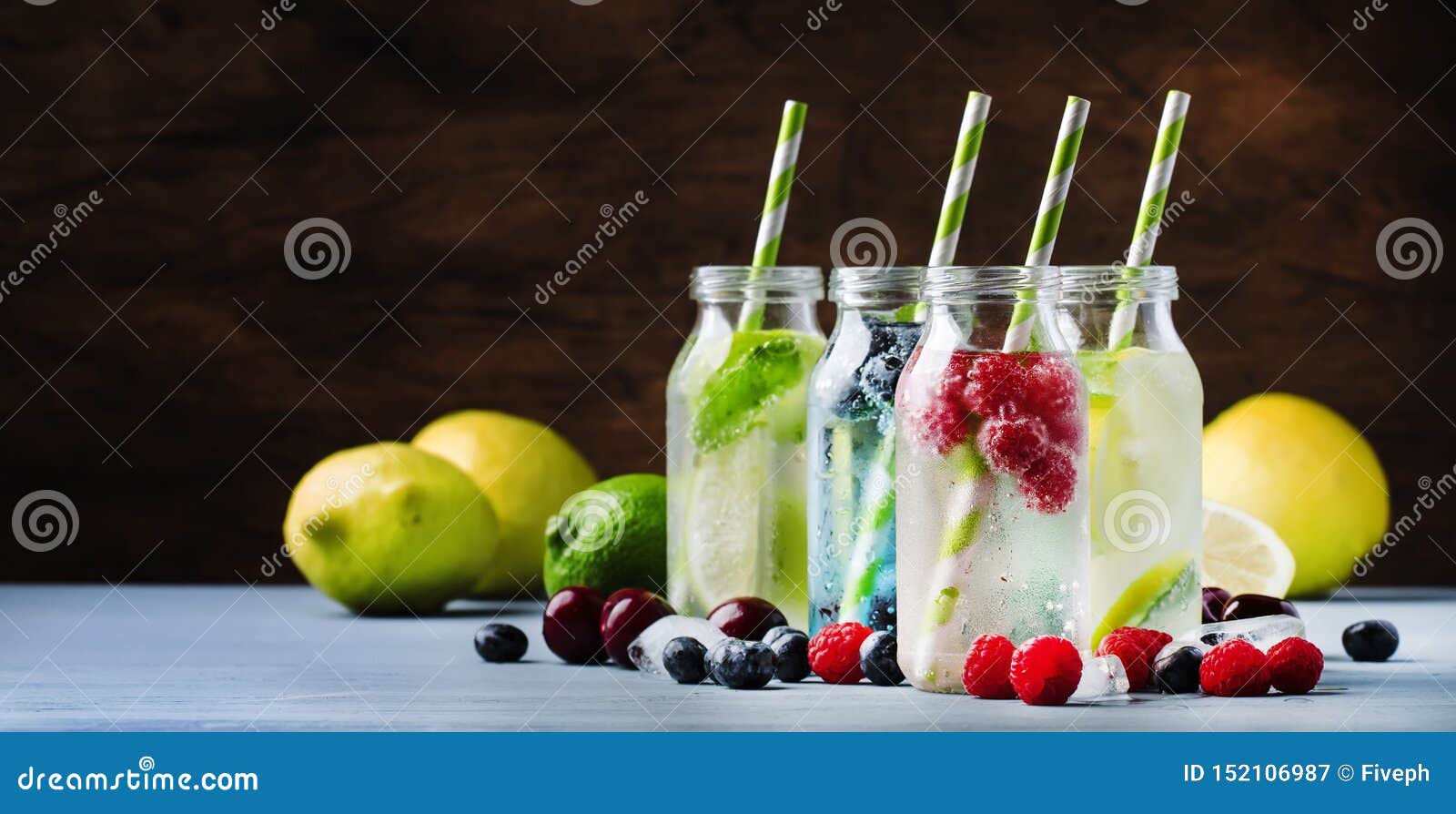summer drinks set. berry, fruit and citrus non-alcoholic refreshing ice cold beverages and cocktails in glass bottles on blue