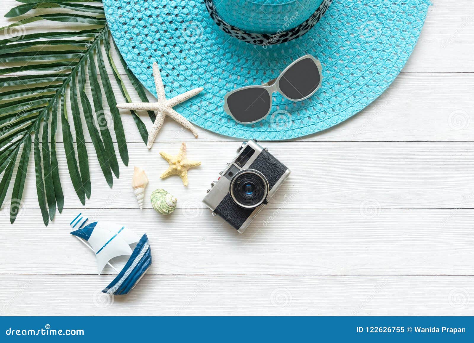 summer fashion, camera, starfish, sunblock, sun glasses, hat. travel and vacations in the holiday, wood white background