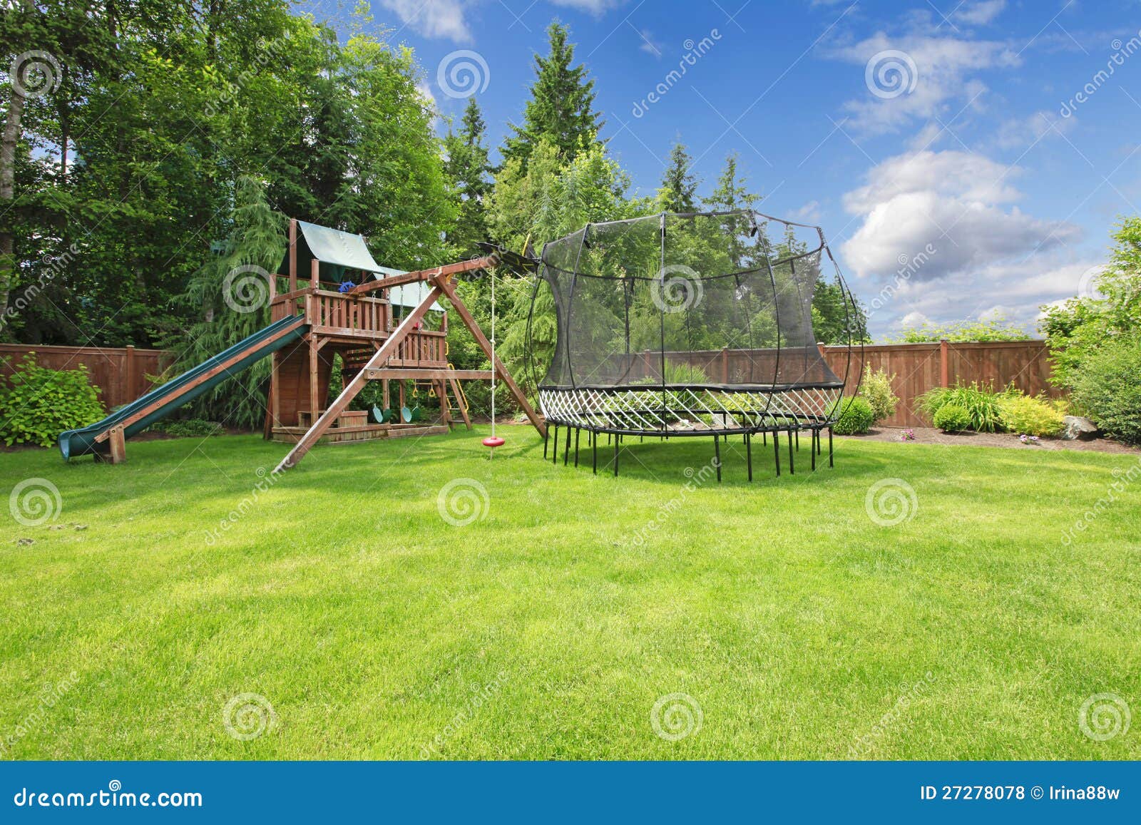 summer fenced backyard with play area.