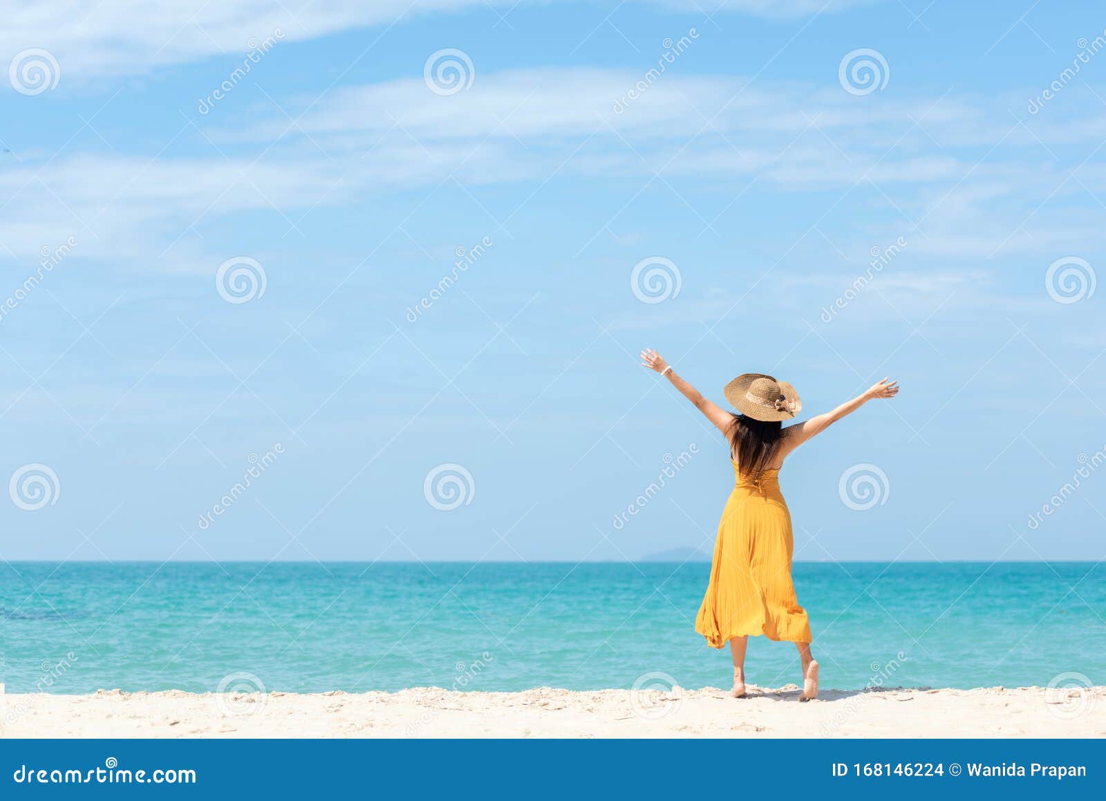 summer holiday. lifestyle woman chill holding big white hat and wearing yellow dress fashion summer trips standing chill on the sa