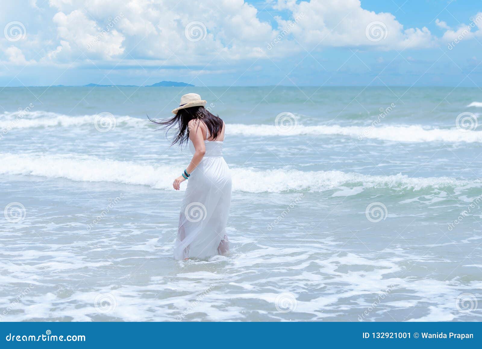 summer holiday. lifestyle woman white dress wearing fashion summer trips walking on the sandy ocean beach. happy woman enjoy and r