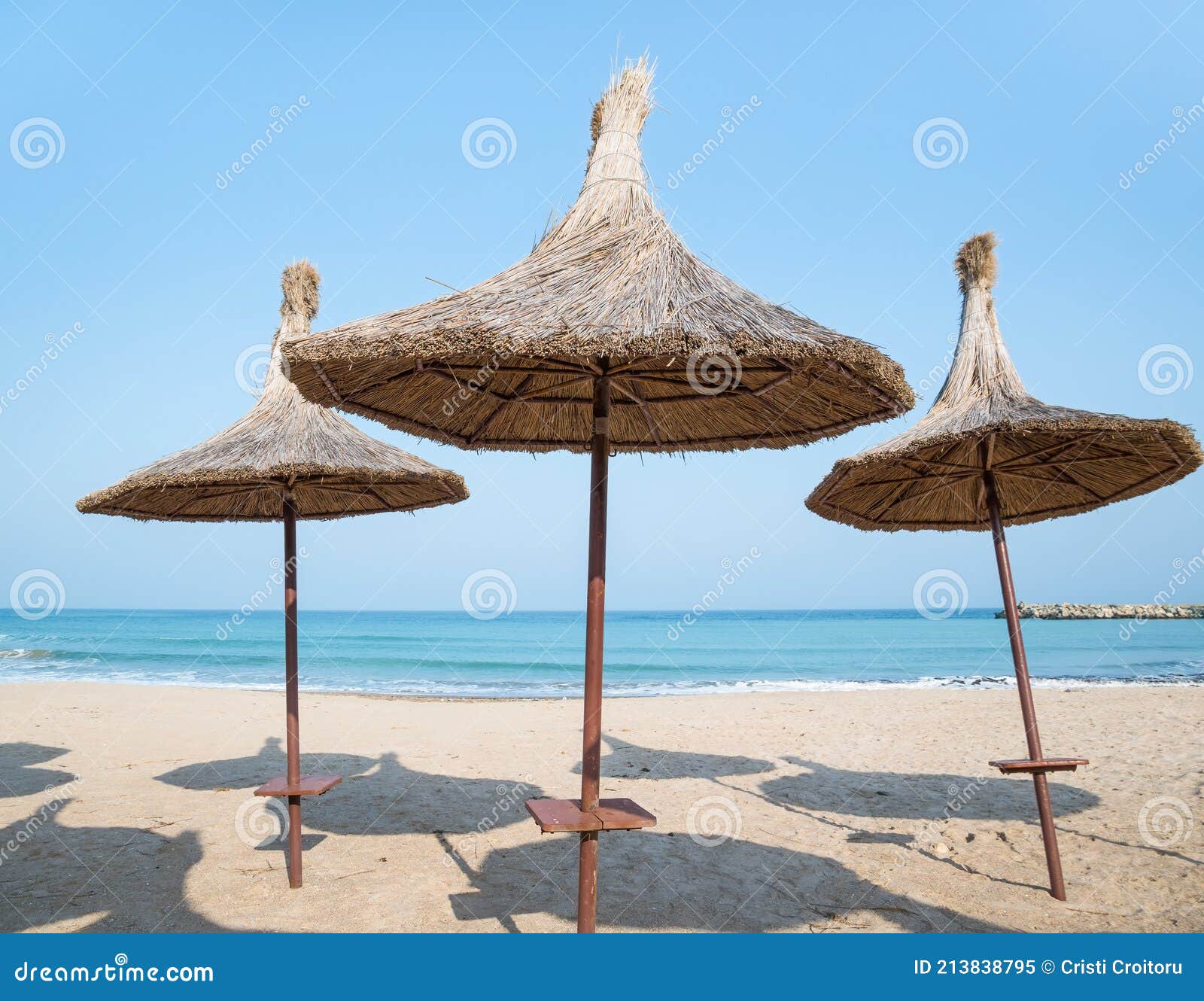 Summer Landscape With Straw Umbrellas On The Beach In Mangalia Or Mamaia Beach At The Black Sea