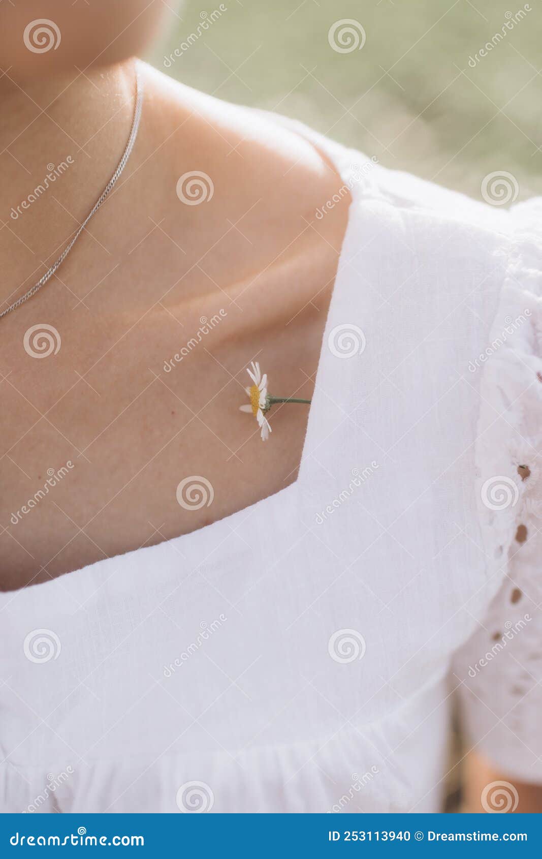 summer portrait. little chamomile flower on a young woman shoulder