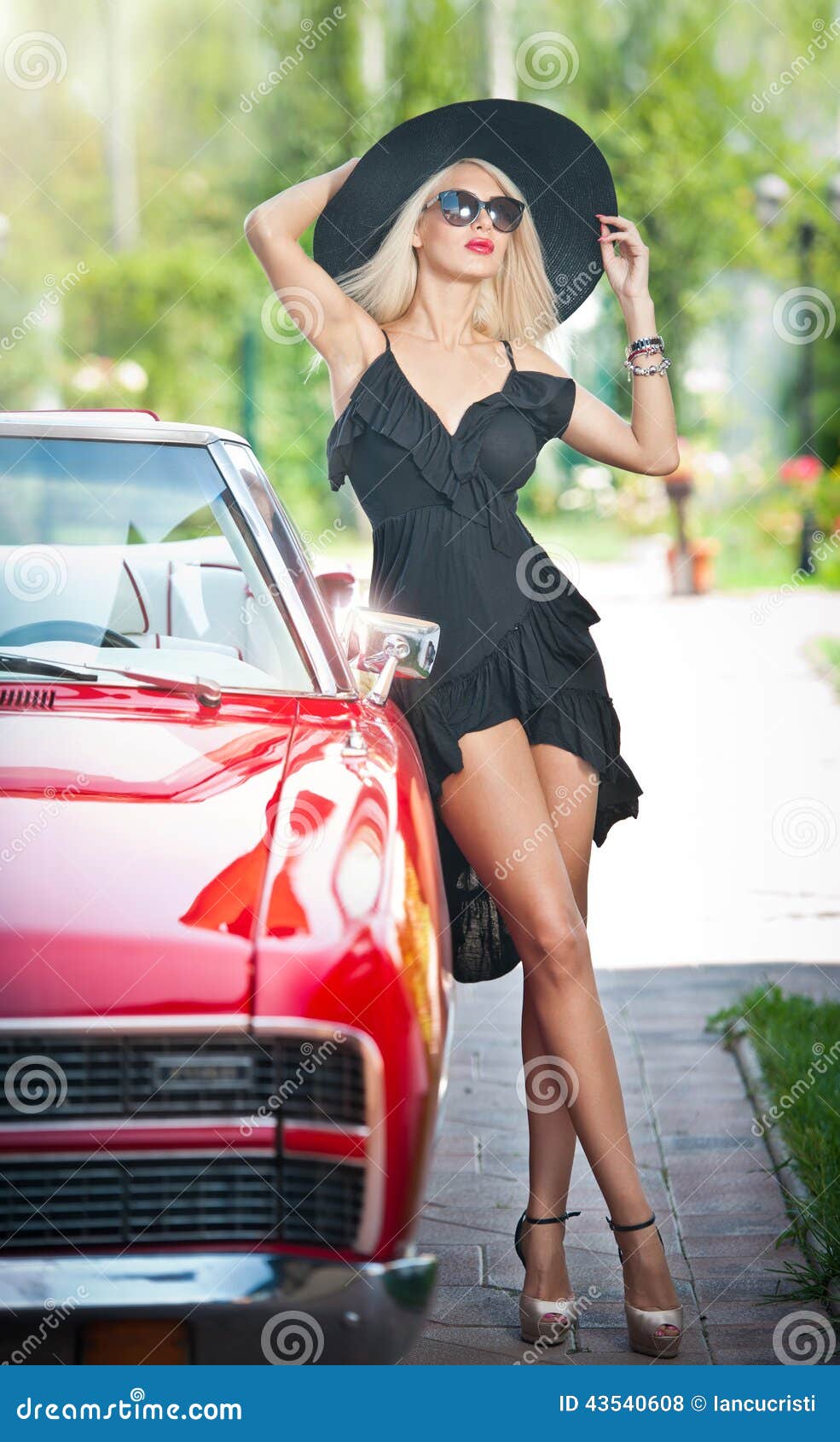 summer portrait of stylish blonde vintage woman with long legs posing near red retro car. fashionable attractive fair hair female