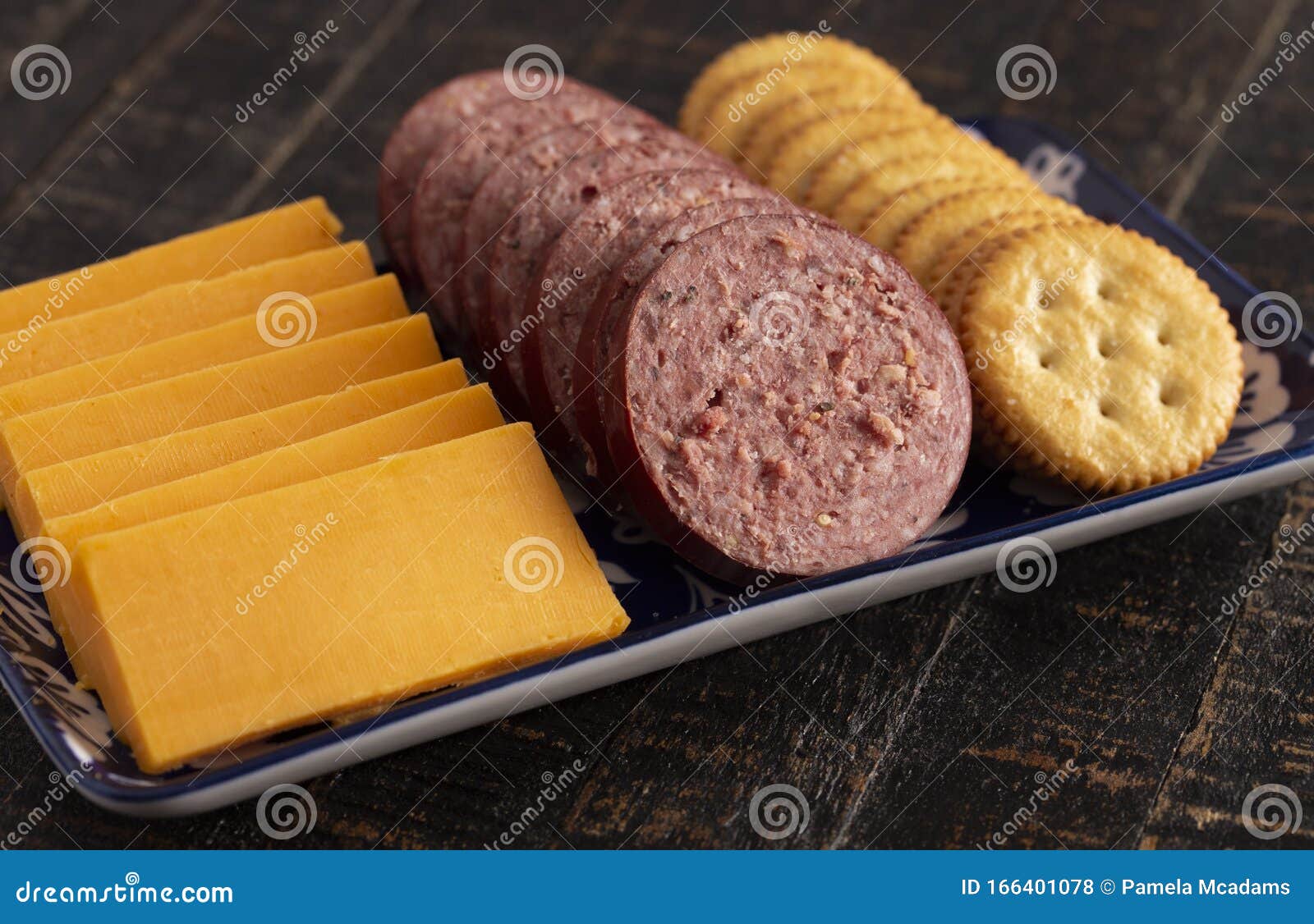Summer Sausage Crackers and Cheddar Cheese on a Rustic Wooden Table