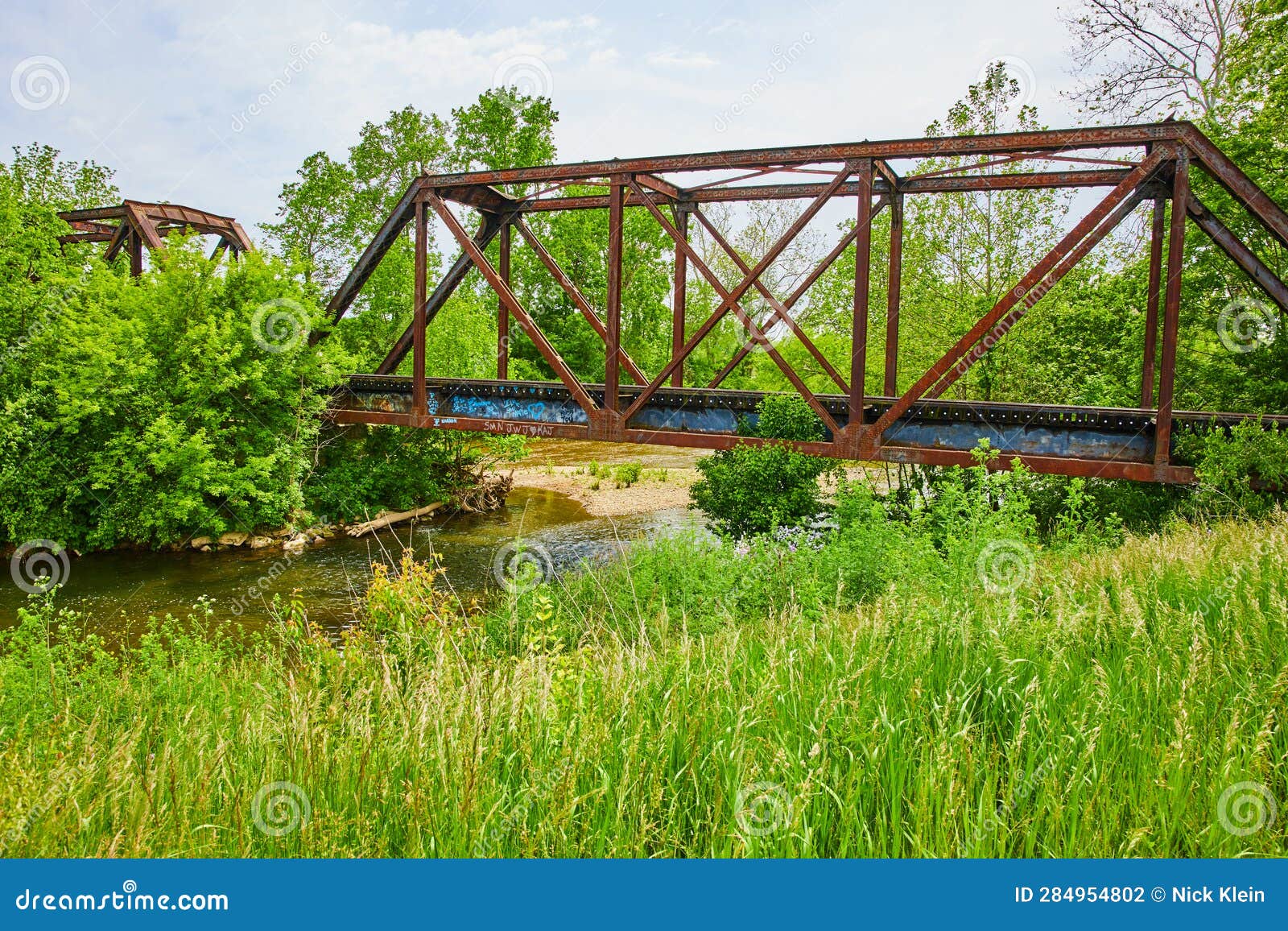 Summer Shot of Kokosing River with Train Bridge and Field of Grass