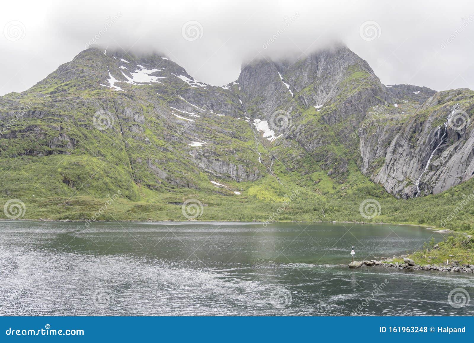 summer snow on steep rocky side of raftenfjord, norway