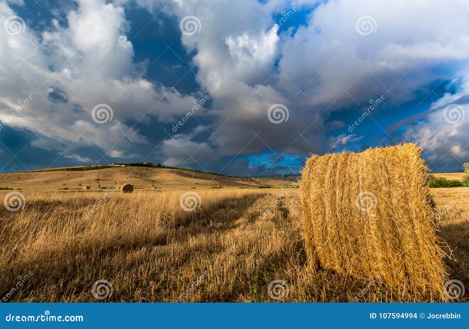 summer storm looms over hay field in tuscany, italy.cr2