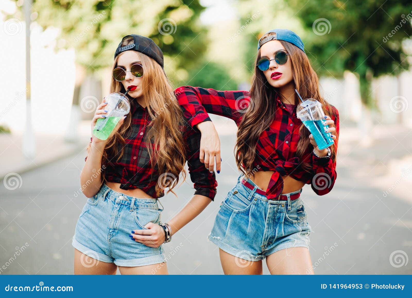 Two chicks in pretty summer outfits walk across the street