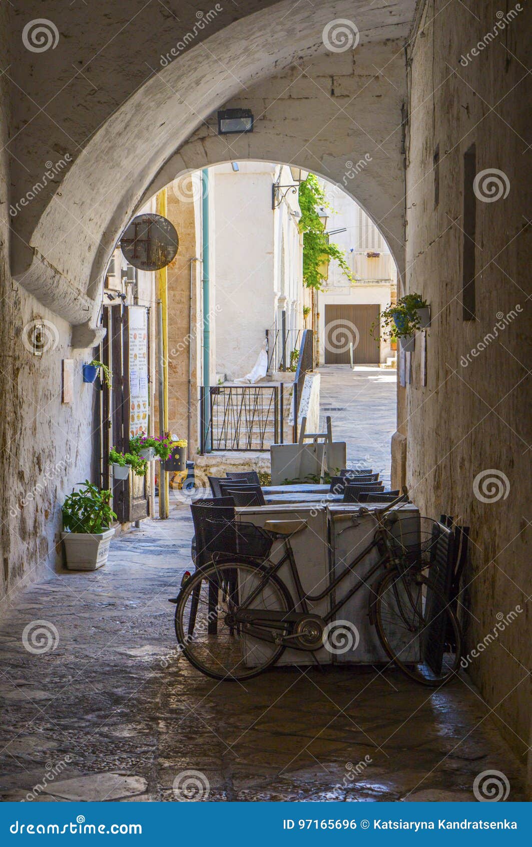 summer terrace cafe in a narrow arched passageway of polignano a mare, italy.