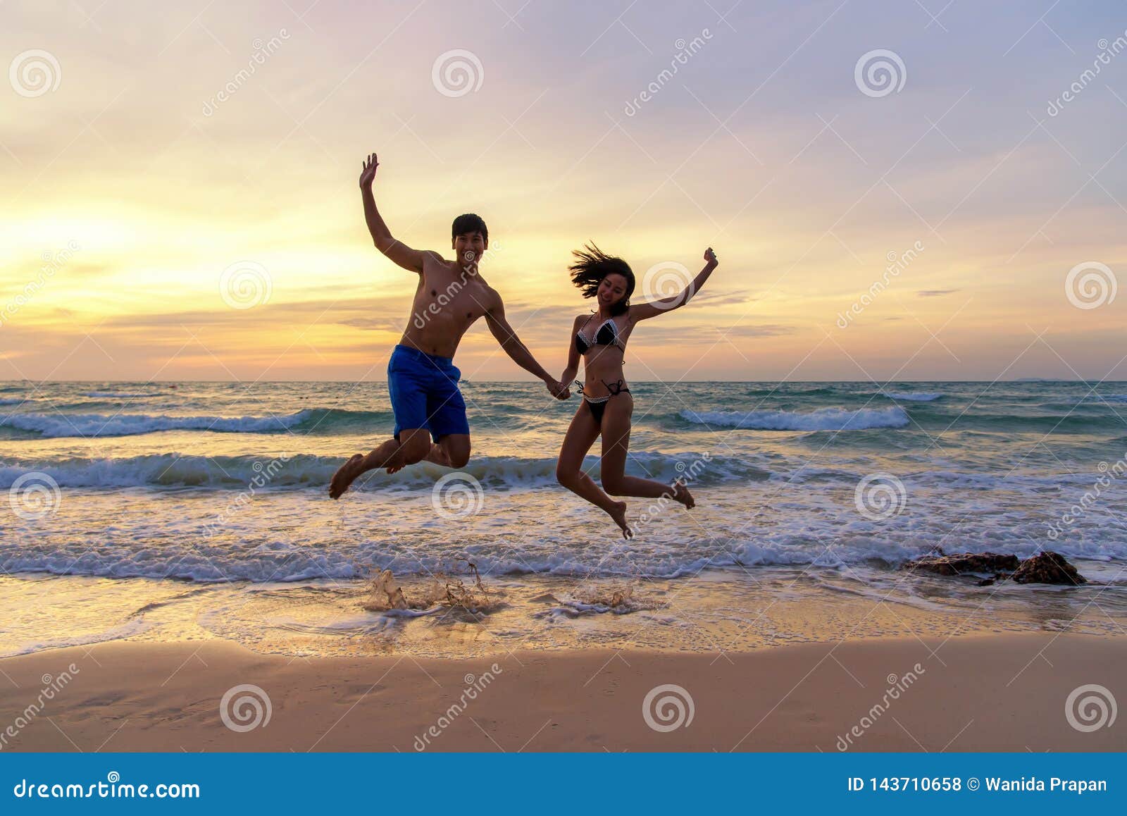 summer vacation.  couple jumping holding hands on tropical on the beach sunset time in holiday trips.  honeymoon holidays people r