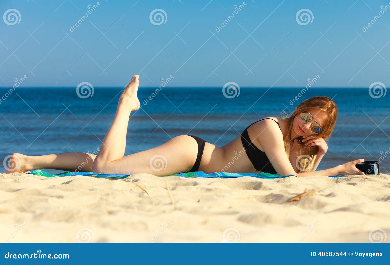 Summer Vacation Girl with Phone Tanning on Beach Stock Photo photo pic