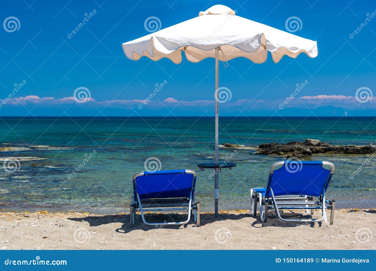 Sun Beds and an Umbrella on the Beach, on the Seashore Stock Image