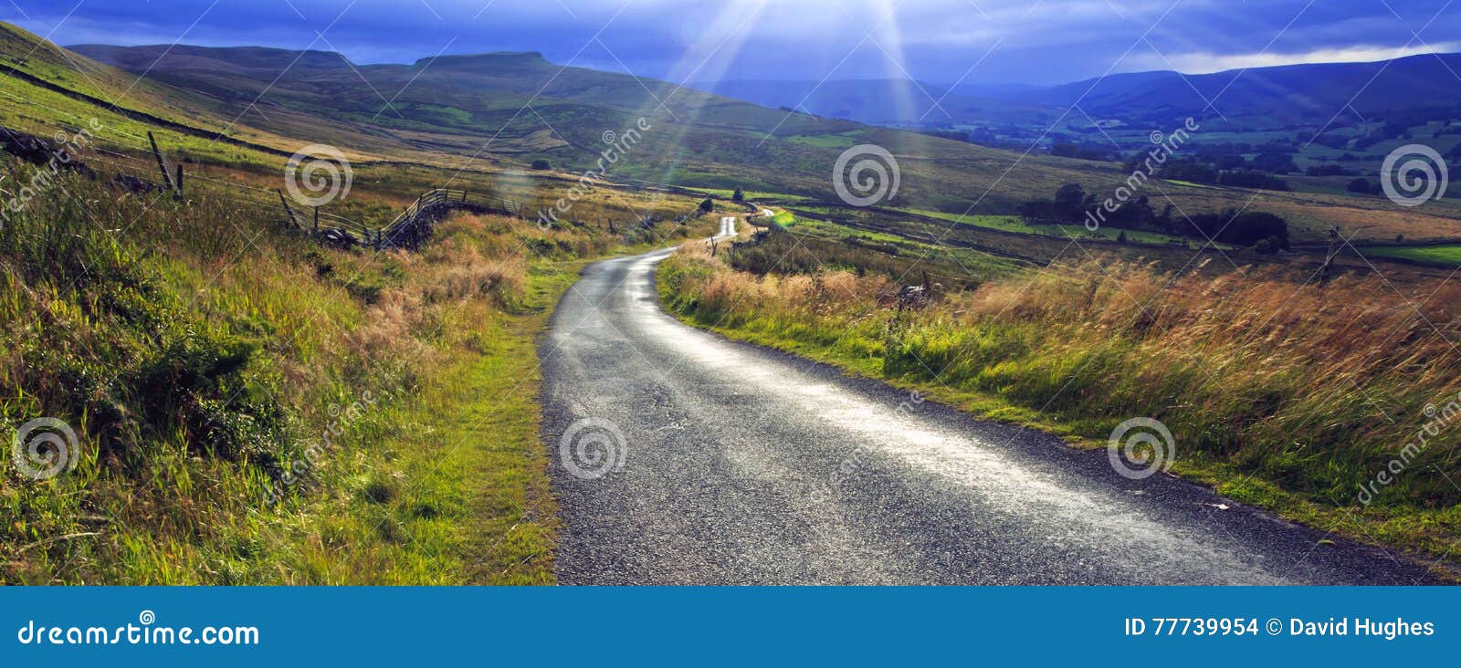 sun bursting through cloud above crag side road yorkshire dales