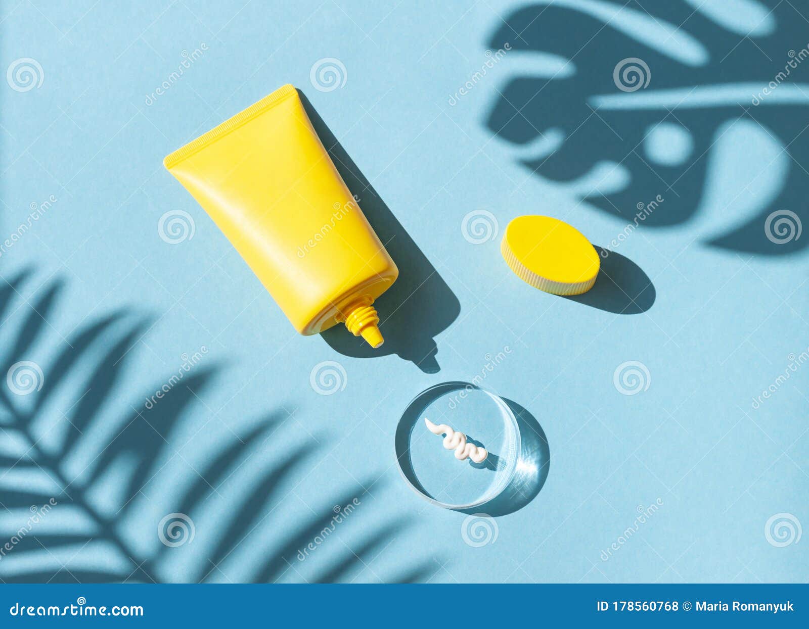 Sun Cream Yellow Tube on the Blue Wet Background with Tropical Leaves ...