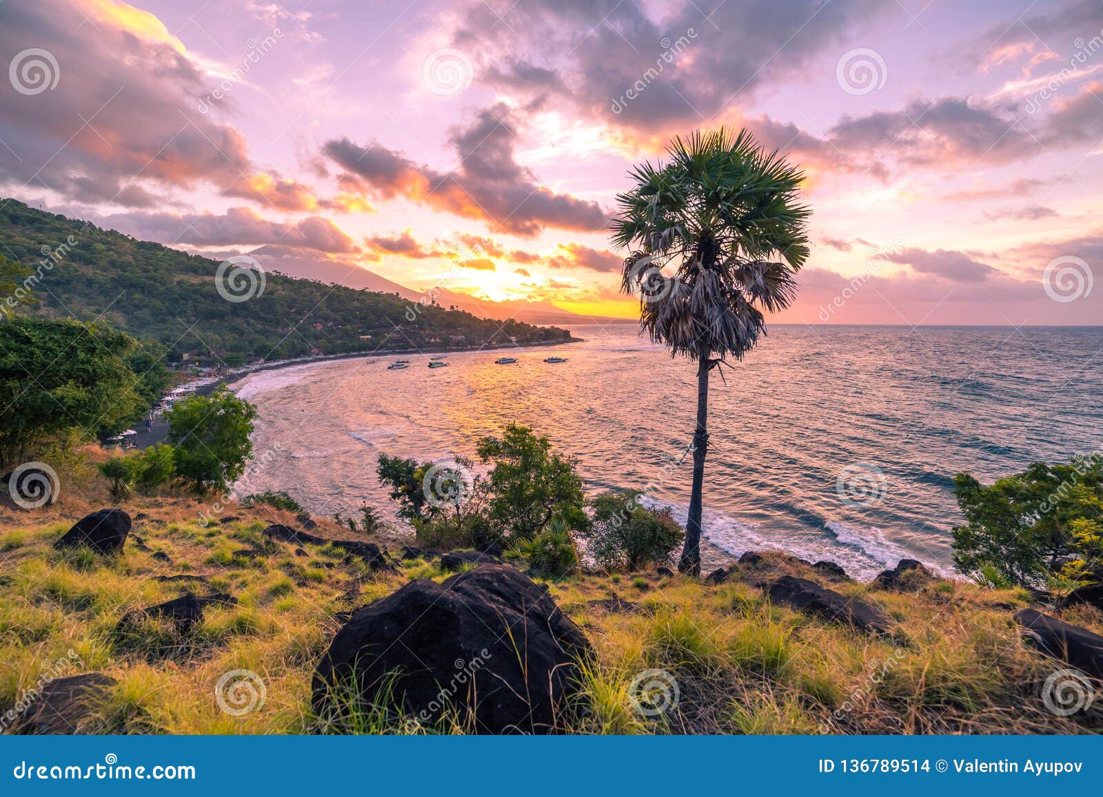the sun is down with colourful sky and clouds in jemeluk bay in amed, bali, indonesia