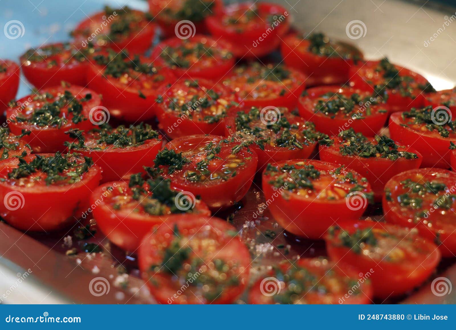 Sun Dried Tomatoes with Herbs and Oil in a Hot Surface Stock Photo