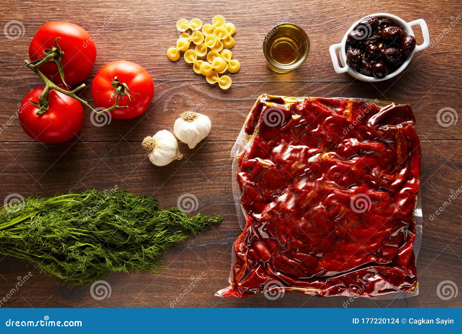 Sun Dried Tomatoes in Vacuum Pack and Vegetables on a Wooden Table