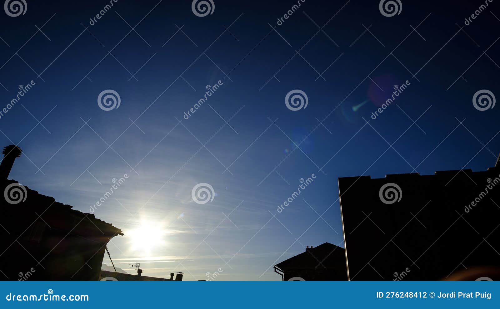 Sun Flare Shining on a Dark Blue Sky with Building Silhouettes Stock ...