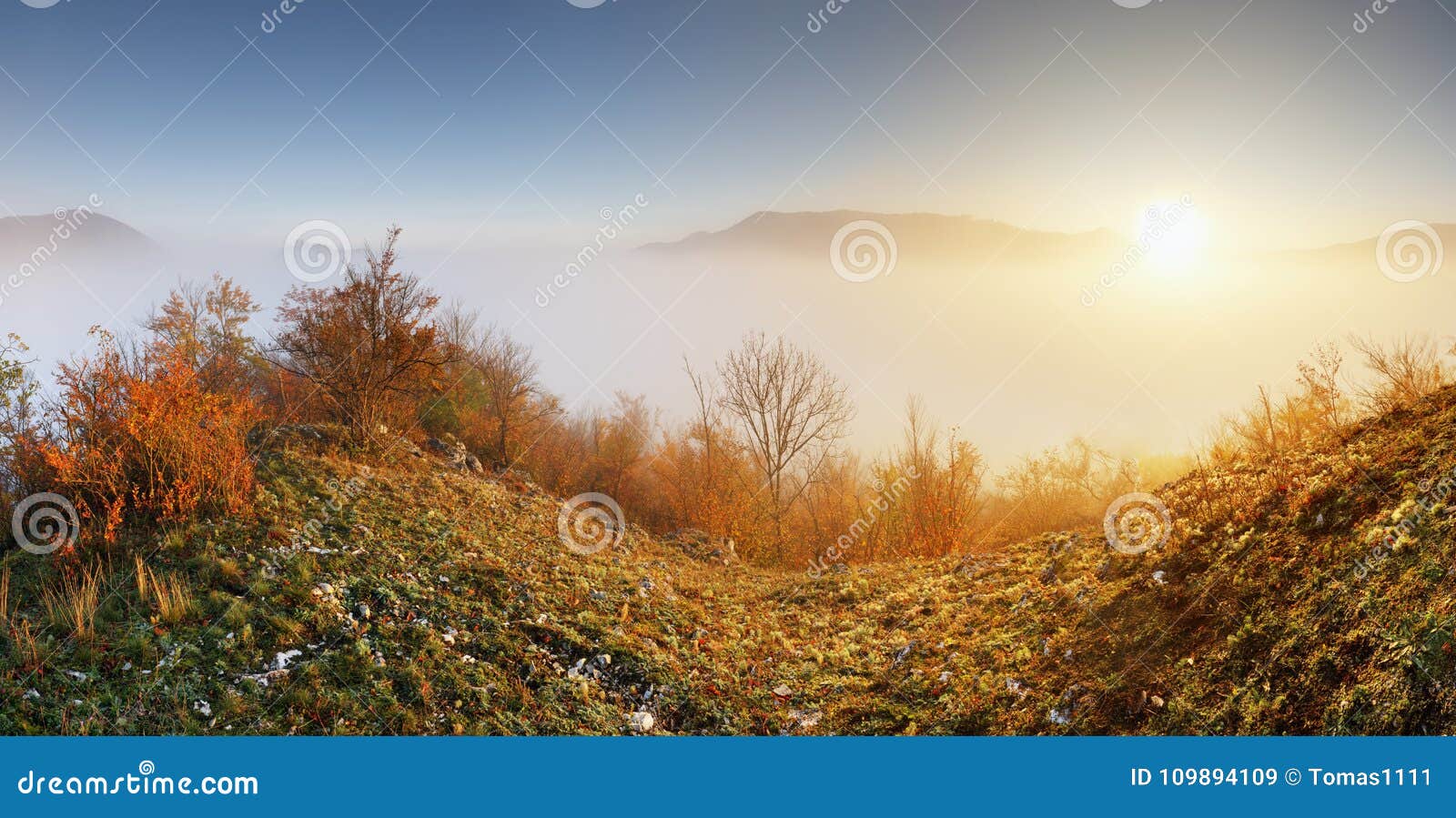 sun over clouds mist in mountain landcape at sunrise