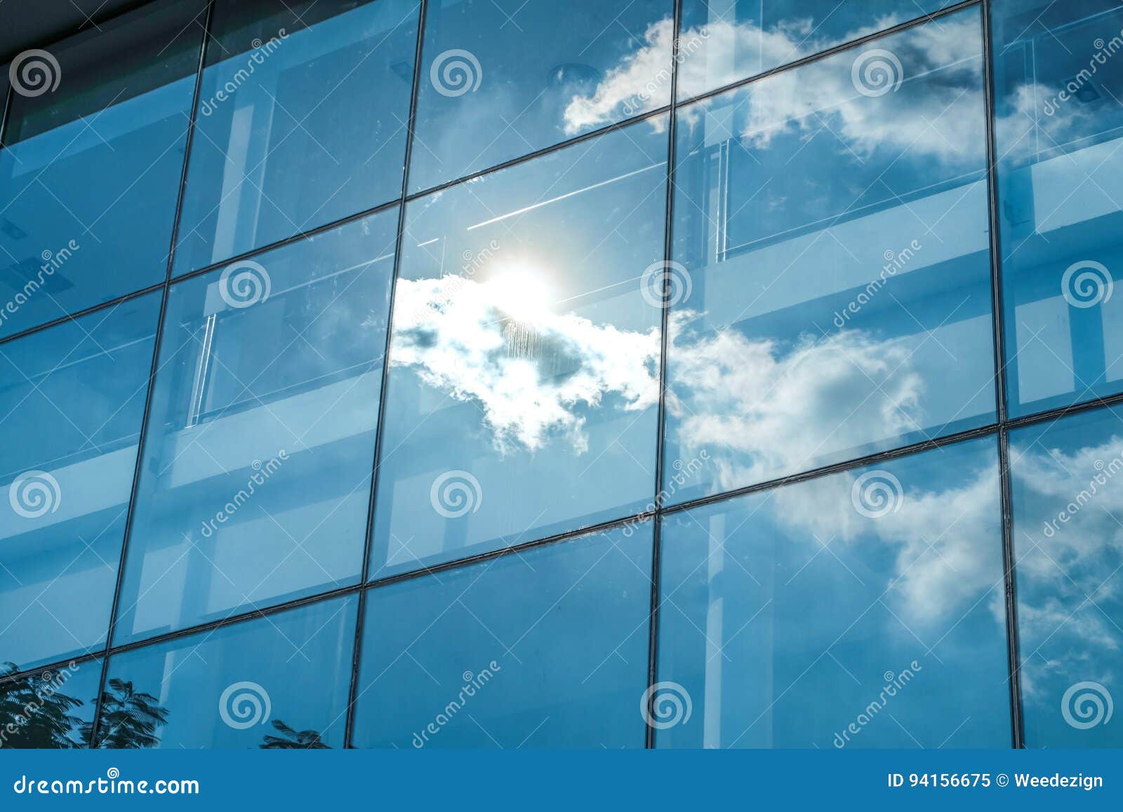 sun ray and blue sky reflection on window office building, business concept