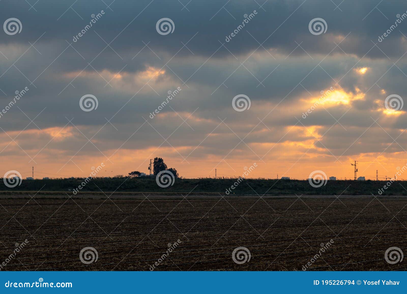 sun sets over agricultural field,