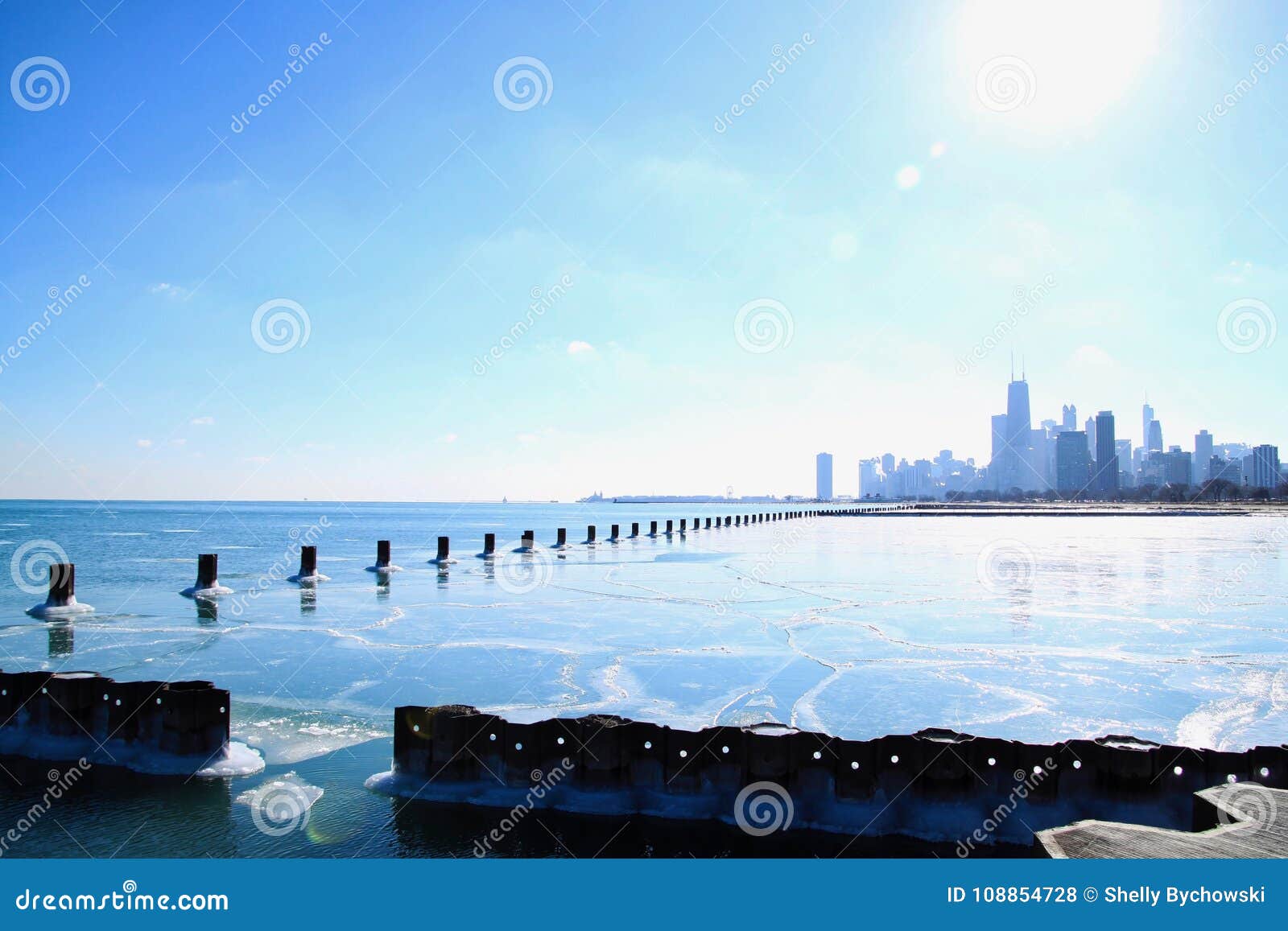 Sun Shines Bright Over Chicago Skyline And A Frozen Lake Michigan In