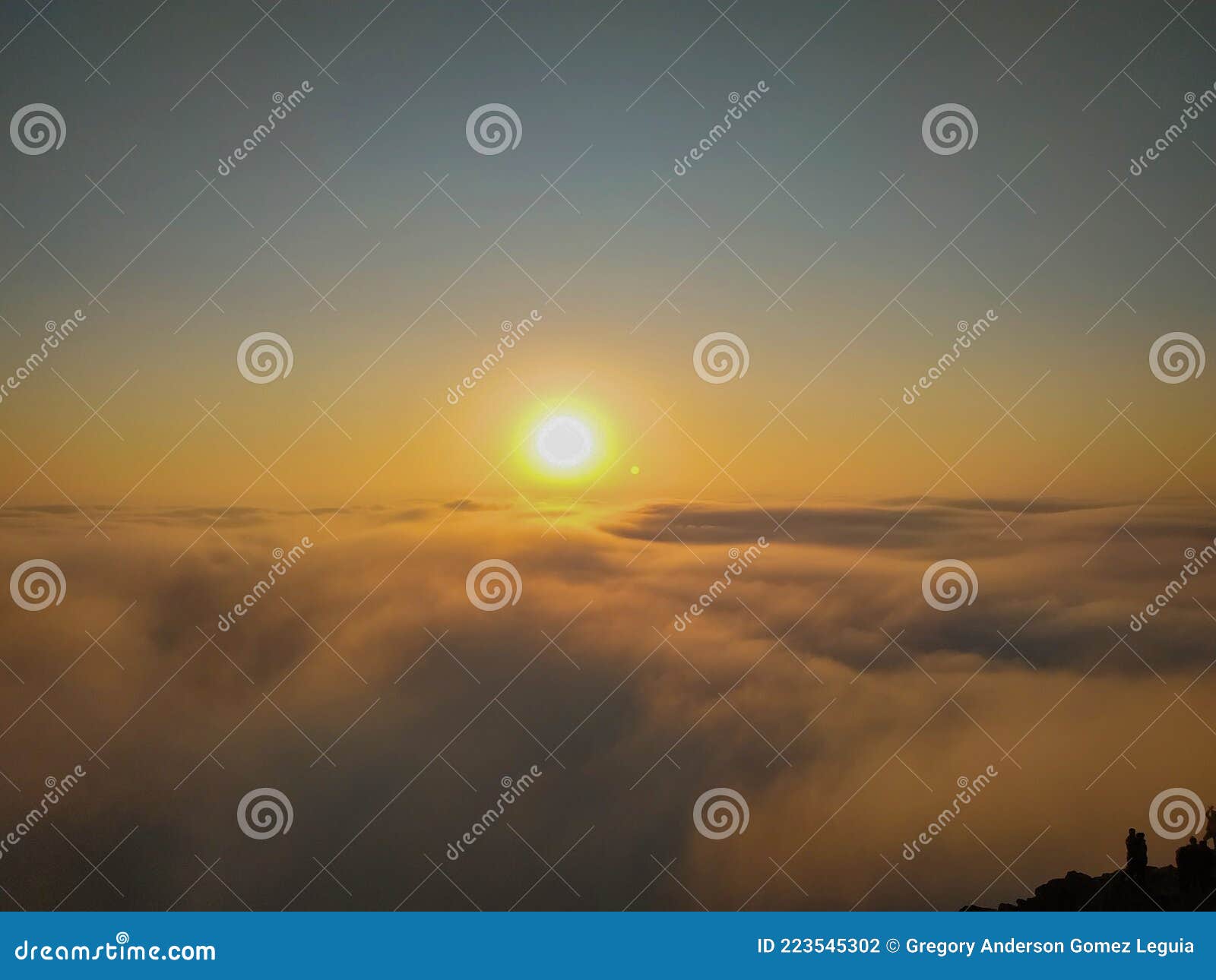 the sun shining above the clouds on a cliff