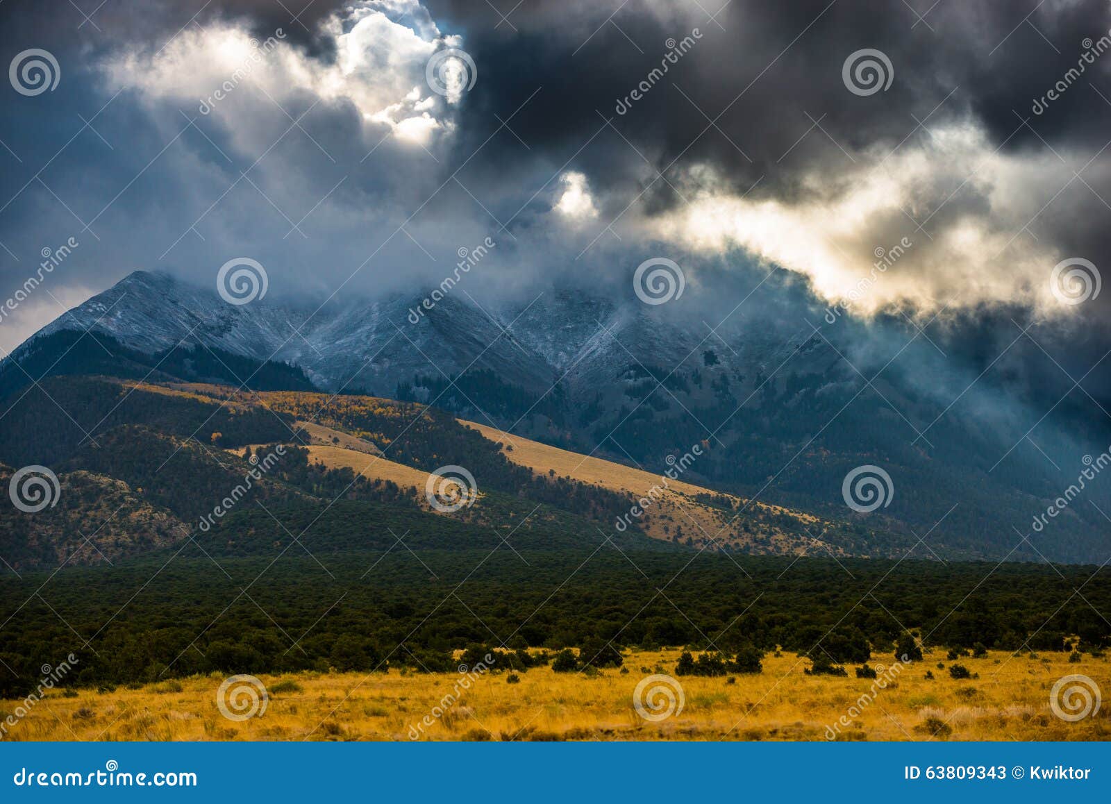 sun shining through the dark clouds over the mountains sand dune