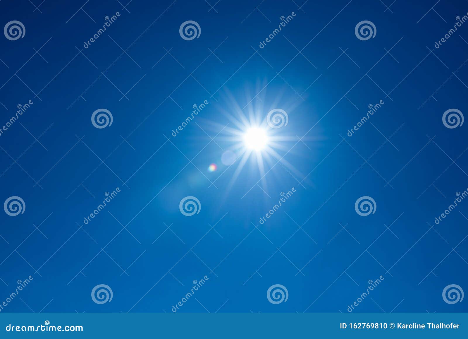 sun, sunbeams against blue sky - cloudless heaven. photography with lense flair effect
