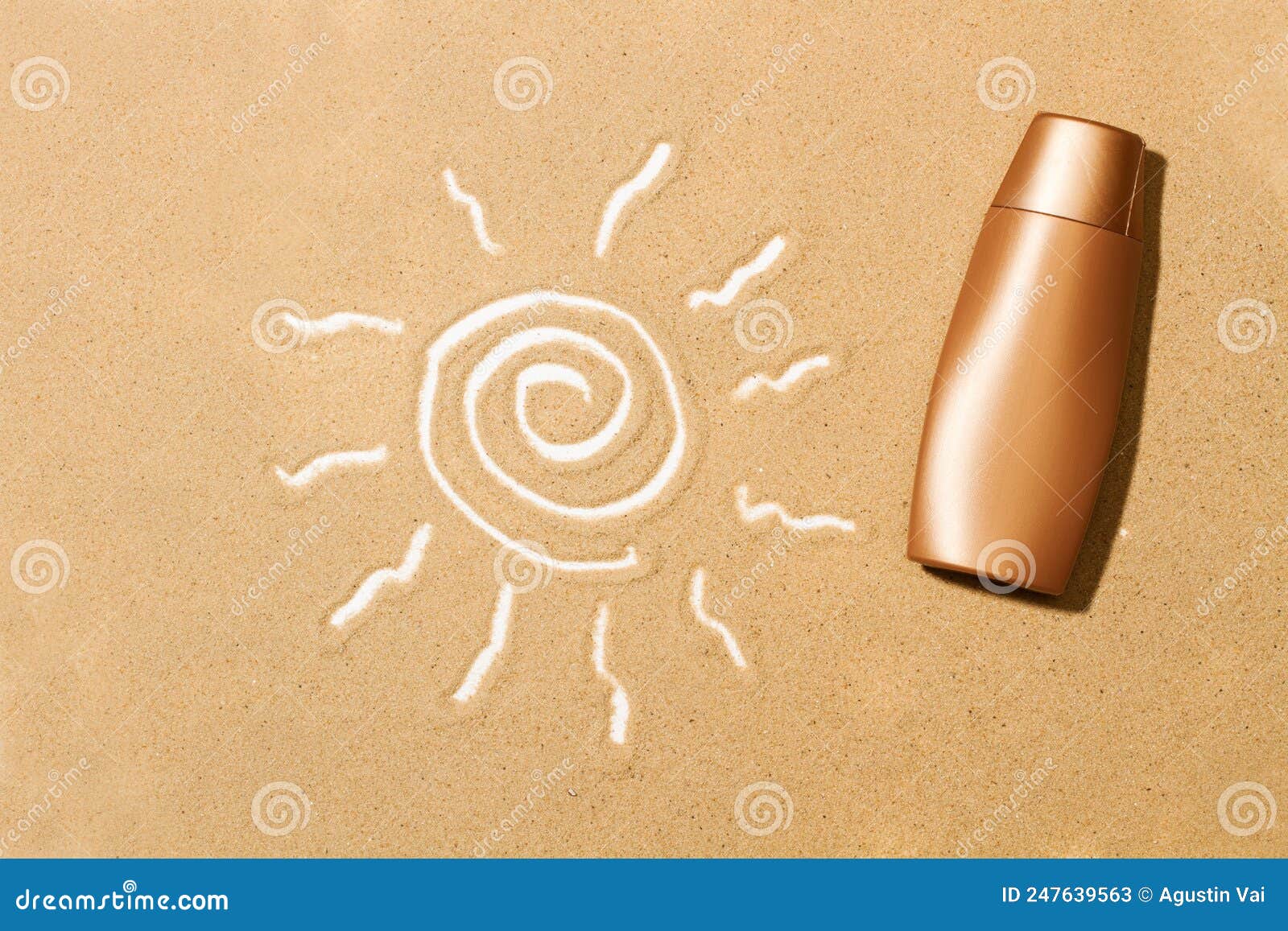 A Sun Tan Lotion Bottle and a Drawing of the Sun on the Sand Stock