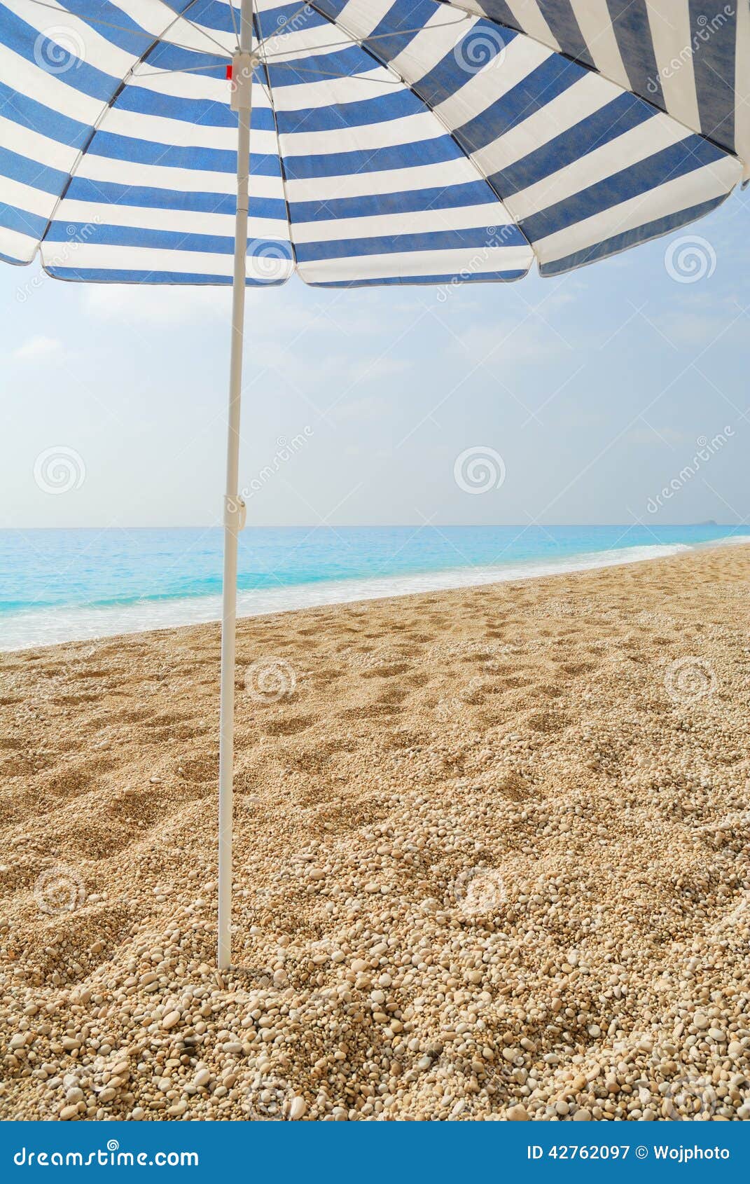 Sun Umbrella Stuck in a Pebble Beach Stock Image Image of rest