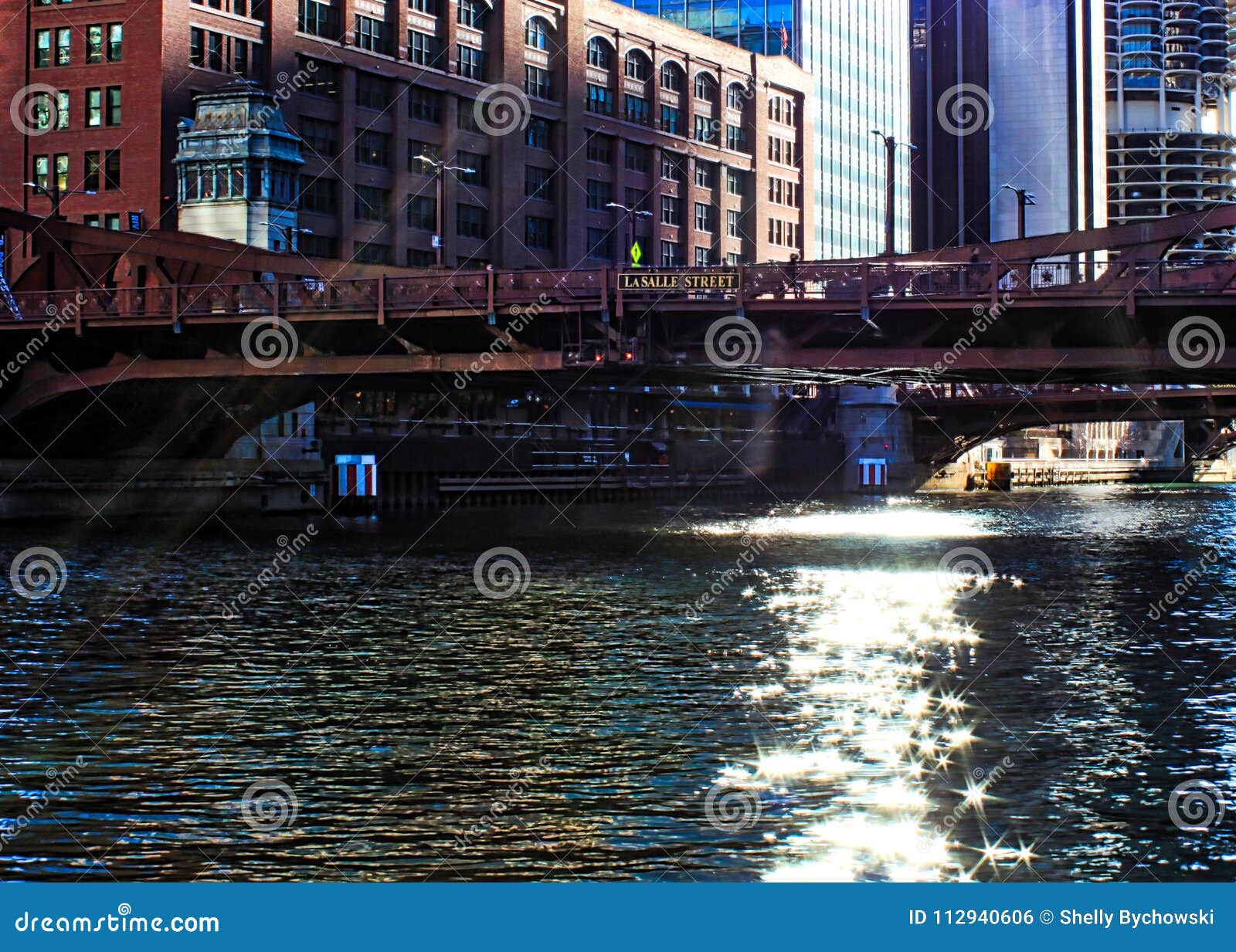 sunbeams extend over the downtown chicago loop, creating glittering stars on the river during morning