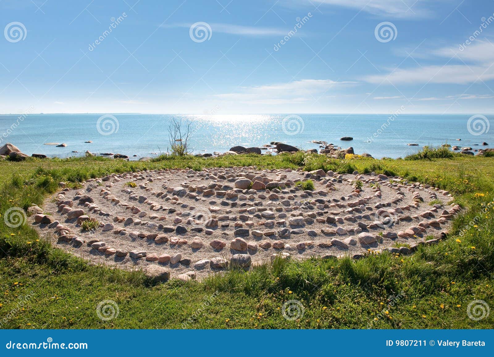 Genere sul litorale di mare con un sundial e un cielo blu di pietra