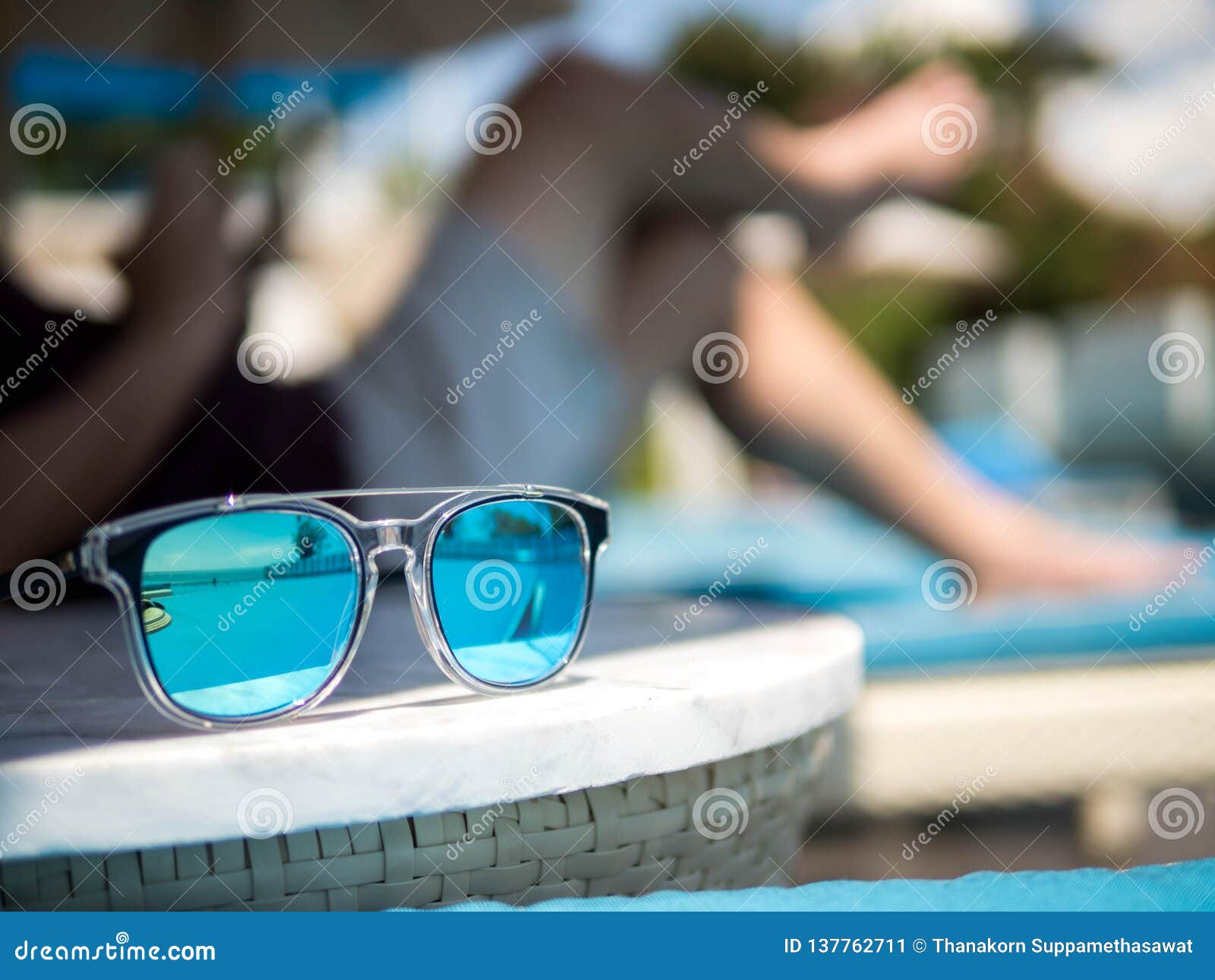 Sunglasses, Men`s Legs Resting in a Swimming Pool Background