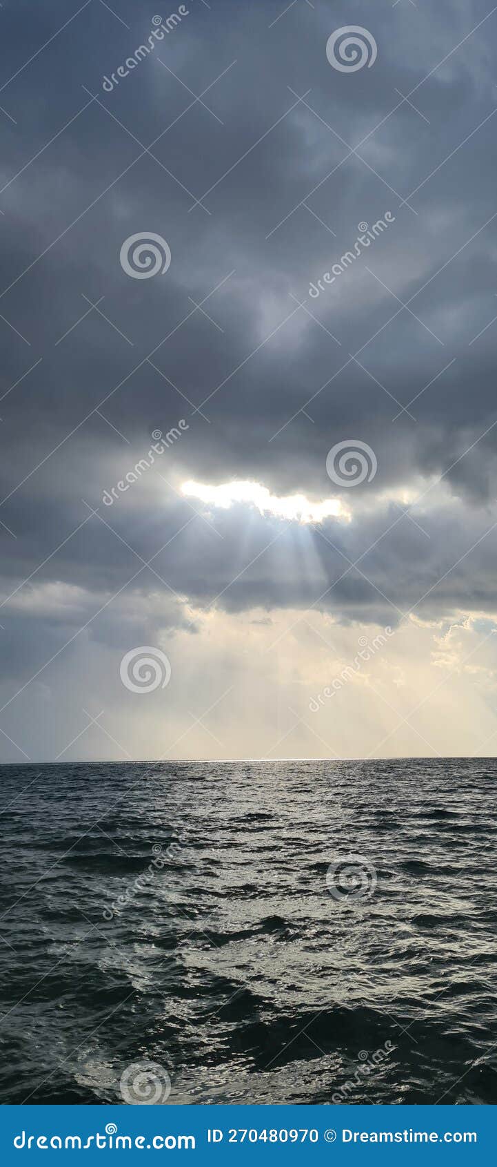 Sunlight on the Sea through the Filter of Rain Clouds Stock Photo