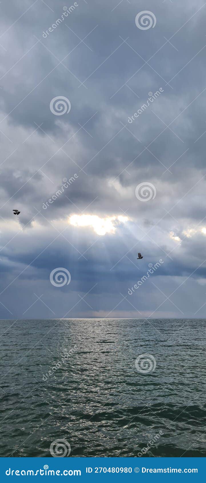 Sunlight on the Sea through the Filter of Rain Clouds Stock Photo