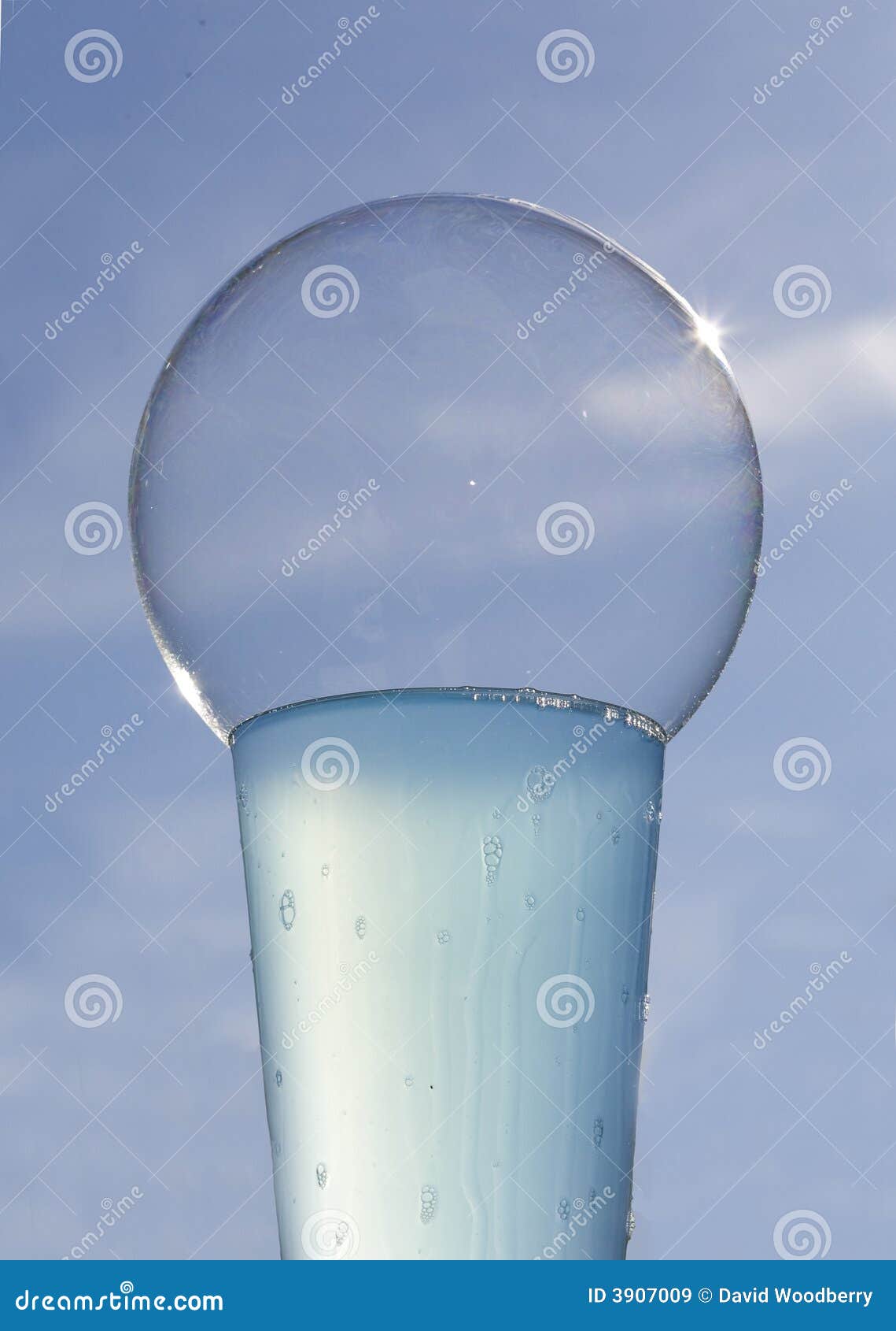 sunlit bubble on glass of blue liquid